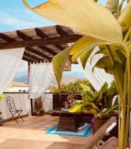 a patio with a wooden pergola and a table at Hostal Boutique Plaza Cantarero in Nerja