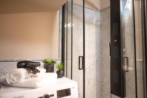 łazienka z prysznicem, umywalką i ręcznikami w obiekcie Petra Apuana Luxury Apartment w mieście Pietrasanta +16 zdjęć