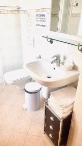 biała łazienka z umywalką i toaletą w obiekcie B&B Nest on the Lake w mieście Lezzeno