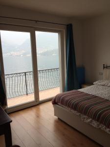 una camera da letto con una grande porta scorrevole in vetro con vista sull'oceano di B&B Nest on the Lake a Lezzeno