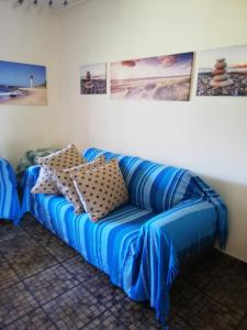 eine blaue Couch in einem Zimmer mit Bildern an der Wand in der Unterkunft Cabanas Del Mar 45 in Kingsborough