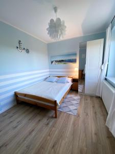 a bedroom with a bed in a room with blue walls at Pokoje Gościnne Mira in Władysławowo