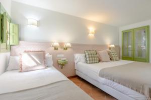 a bedroom with two beds and a couch at La Abadia de Giralda in Seville