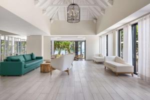 a living room with a blue couch and chairs at Radisson Blu Azuri Resort & Spa in Roches Noires +145 photos
