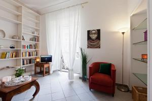 een woonkamer met een rode stoel en een tafel bij Gianicolo Holiday House in Rome