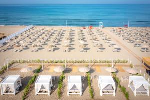 - une vue aérienne sur une plage dotée de chaises et de parasols dans l'établissement Oleandri Resort Paestum, à Paestum