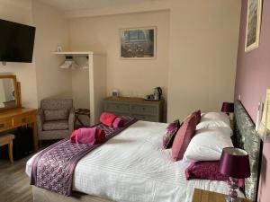 a bedroom with a bed with pink and white pillows at The Quies in Newquay