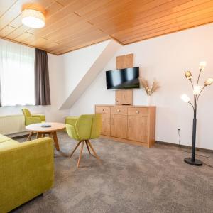 a living room with a couch and a tv at Die Landpension FernW in Willingen