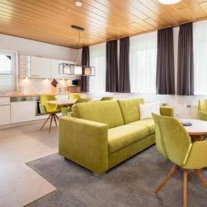 a living room with a yellow couch and a kitchen at Die Landpension FernW in Willingen