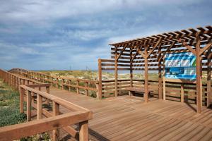 a wooden deck with a bench on the beach at apart@CostaSantoAndré Beach in Santiago do Cacém