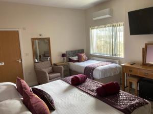 a hotel room with two beds and a desk at The Quies in Newquay