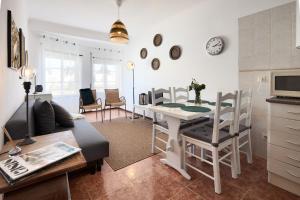 a kitchen and living room with a table and chairs at apart@CostaSantoAndré Beach in Santiago do Cacém