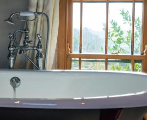 uma banheira na casa de banho com uma janela em Sunnyside Bed and Breakfast em Longnor