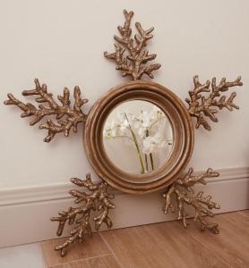 a mirror on a wall with flowers in it at Hostal Boutique Plaza Cantarero in Nerja