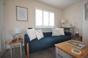 a living room with a blue couch and a table at Corner Cottage in Cambridge