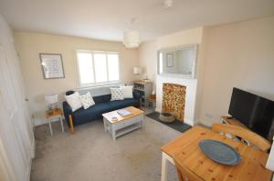 a living room with a blue couch and a tv at Corner Cottage in Cambridge