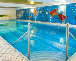 a large swimming pool with blue tiles on the wall at Hotel Seestern in Wasserburg am Bodensee