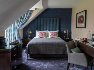 um quarto com uma cama e uma parede azul em Clandeboye Lodge Hotel em Bangor