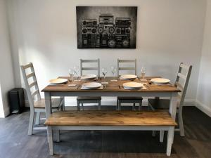 a dining room table with chairs and a picture of a camera at Stanford Villa in Stanford-le-Hope