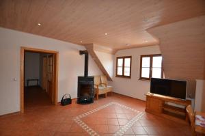 a living room with a fireplace and a flat screen tv at Hofgut Metzler in Gau-Heppenheim