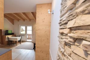a kitchen and living room with a stone wall at Aurturist Sesto in Sesto