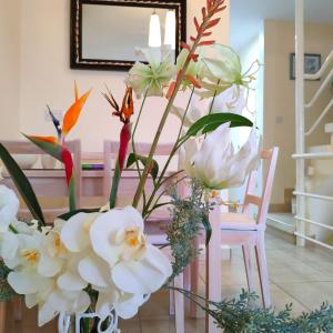 a vase filled with white flowers in a room at SWEET HOME CORAL BAY SEA VIEW 3 Stocks Paphos Peyia in Peyia