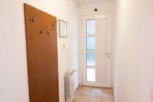 a hallway with a wooden door and a window at Apartma Categorical in Portorož +11 photos