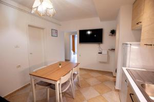 eine Küche und ein Esszimmer mit einem Holztisch in der Unterkunft Apartma Categorical in Portorož