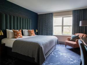 una camera da letto con un letto, una finestra e una sedia di Clandeboye Lodge Hotel a Bangor