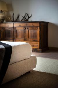 a wooden dresser in a room with a couch at San Calisto camere con vigna in Popoli