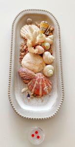 a tray filled with different types of shells on a table at SWEET HOME CORAL BAY SEA VIEW 3 Stocks Paphos Peyia in Peyia +85 photos