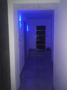 un pasillo vacío con luces azules en una habitación en maison à la campagne prés de la ville, en Aiglemont