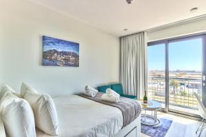 1 dormitorio con cama y ventana grande en Stunning work pad on 1onAlbert- 601 en Ciudad del Cabo