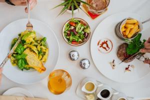 una mesa blanca con platos de comida. en Hotel & Apartments Ventus Rosa, en Bielsko-Biala