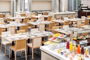 a room filled with tables and chairs with food on them at NH Collection Berlin Mitte Friedrichstrasse in Berlin