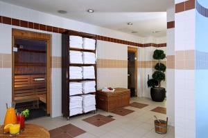a bathroom with a stack of towels on a wall at NH Collection Berlin Mitte Friedrichstrasse in Berlin