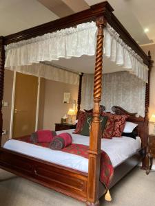 a bedroom with a four poster canopy bed at The Quies in Newquay