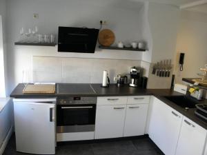 a kitchen with white cabinets and a black counter top at Altstadtwohnung in Verden