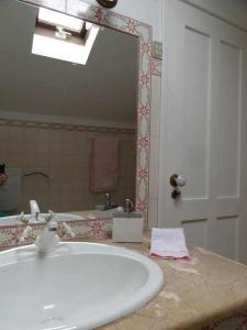 ein Badezimmer mit einem Waschbecken und einem großen Spiegel in der Unterkunft Casa dos Pocinhos Férias tranquilas no campo in Torres Novas