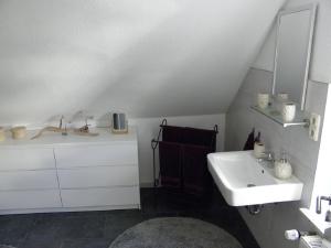 a white bathroom with a sink and a mirror at Altstadtwohnung in Verden