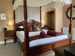 a bedroom with a canopy bed with pillows on it at The Quies in Newquay