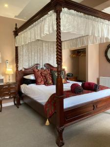 a bedroom with a canopy bed with red pillows at The Quies in Newquay