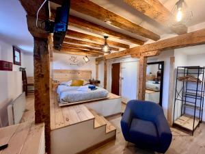 1 dormitorio con 1 cama y 1 silla azul en Loft con encanto en el Corazon de Burgos- Dauda -ATUAIRE- en Burgos