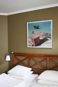 een slaapkamer met een bed en een foto van een strand bij SOFS boutique hotel in Aarhus