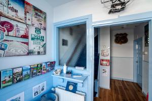 ein Zimmer mit einer blauen Wand mit Plakaten an der Wand in der Unterkunft Pension Sixtysix in Zandvoort