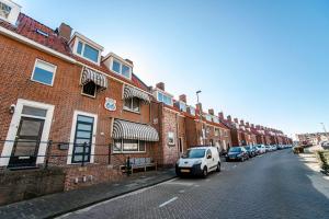une voiture blanche garée devant un bâtiment en briques dans l'établissement Pension Sixtysix, à Zandvoort