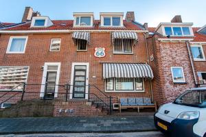 un bâtiment en brique rouge avec un panneau. dans l'établissement Pension Sixtysix, à Zandvoort