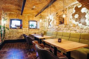 a restaurant with wooden tables and chairs in a room at Hotel Buchenland in Gura Humorului
