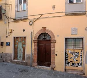un edificio con una puerta marrón y dos ventanas en Umbrian Concierge - Factory House La Viola, en Perugia