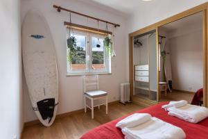 a bedroom with a surfboard hanging on the wall at Spacious Beach Flat in Costa Caparica by SoulPlaces in Costa da Caparica